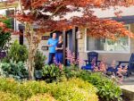 A couple poses in front of their house