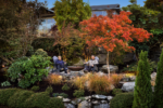 A couple sits by a fire pit on a stone patio, enjoying the view